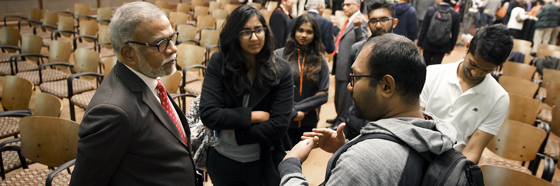 An international student talks with a lecturer after class.