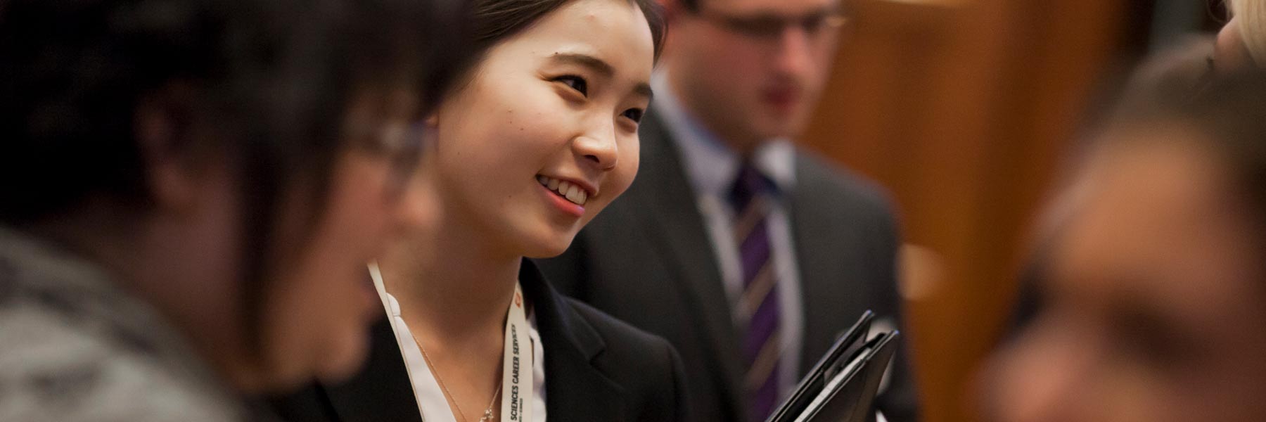 A graduate student scholarship awardee smiles at an event. 