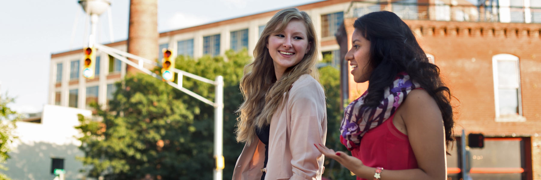 Two students walk in the city and talk about their scholarship opportunities.