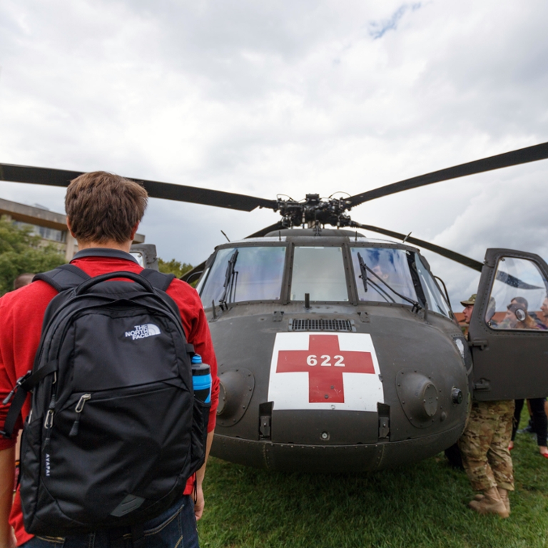 A student looks at a National Guard rescue helicopter.